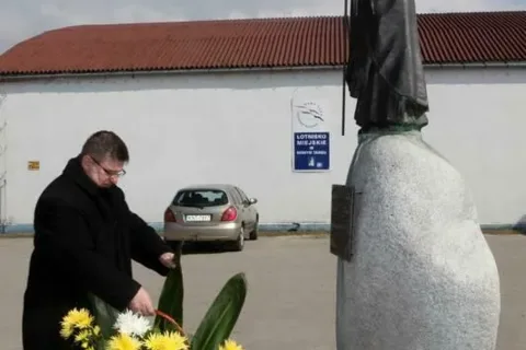Kwiaty pod pomnikiem i tablicą Jana Pawła II